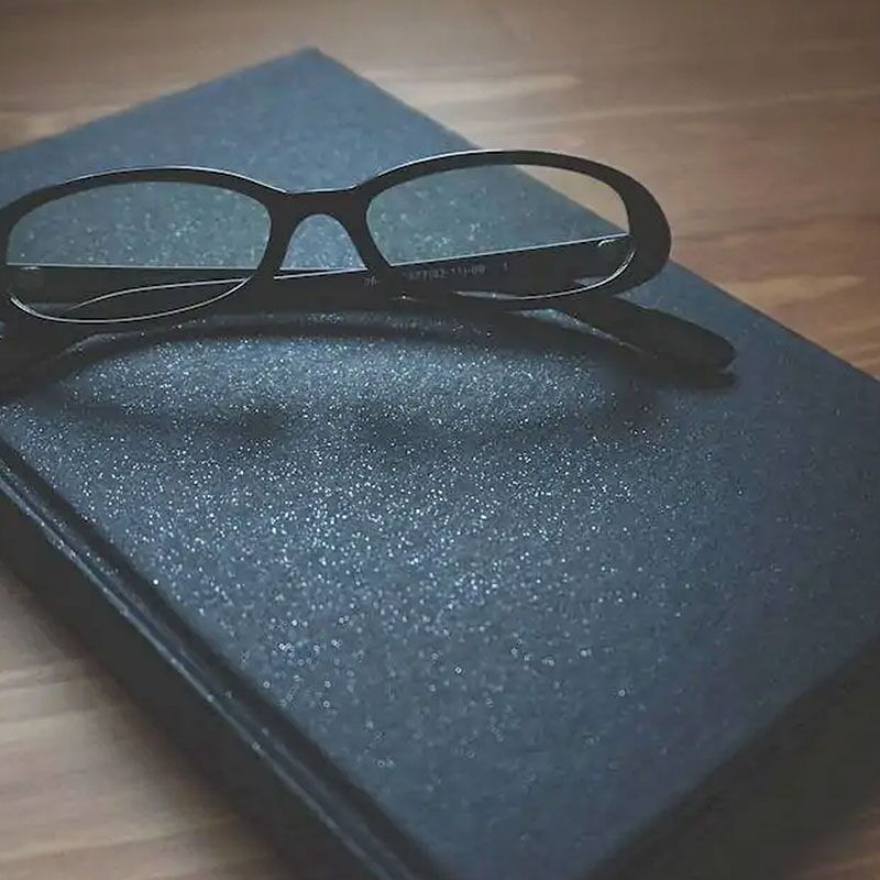 Brille auf einem geöffneten Buch, symbolisch für Businessplan-Coaching über das Jobcenter